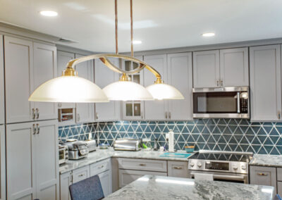 pendant lights over island, recessed lighting, under cabinet lighting in a kitchen with new modern appliances